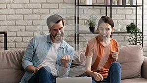 Happy young spouses getting email with loan approval from bank photo