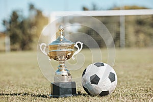 Win, field and football and trophy for sports, game award and achievement in a contest. Fitness, grass and a prize or