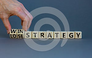 Win-lose strategy symbol. Businessman turns wooden cubes and changes words lose strategy to win strategy. Beautiful grey table,