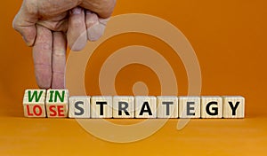 Win-lose strategy symbol. Businessman turns wooden cubes and changes words lose strategy to win strategy. Beautiful orange table,