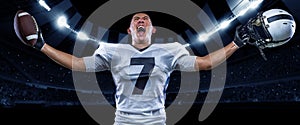 Win, success. Poster with excited american football player in sports equipment holding the ball against night stadium