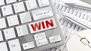 WIN text on a keyboard wirh chart and pencil