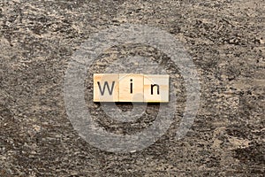 WIN word written on wood block. WIN text on cement table for your desing, concept