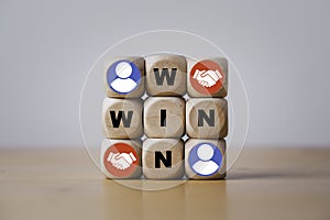 Win and win wording with hand shaking icon on wooden cube block for success and business deal situation concept