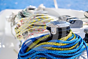 Winch with colourful yellow-blue rope on sailing boat