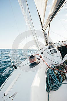 Winch and nautical ropes on deck of sailboat