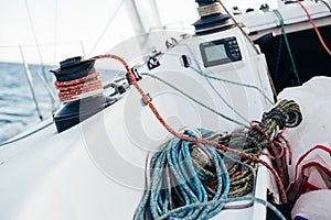 Winch and nautical ropes on deck of sailboat