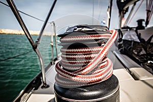 Winch with red and white rope on sailing boat in the sea