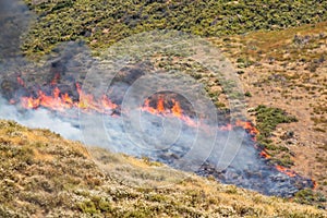 Winchester, CA USA - June 14, 2020: Cal Fire aircraft drops fire retardant on a dry hilltop wildfire near Winchester, California