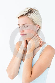 Wincing woman suffering from neck ache photo