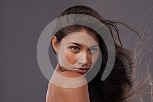 Wind, blow dry and closeup of woman for hair care, treatment and beauty with mockup space isolated on studio background