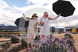 Wind blowing umbrellas Mother of Bride and daughter winery wedding