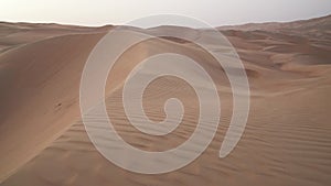 Wind chases the sand over beautiful dunes in the Rub al Khali desert before sunset United Arab Emirates stock footage