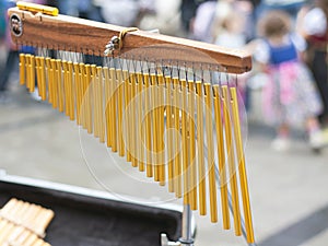 Wind chime pipes with croud in background photo