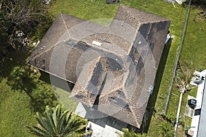 Wind damaged house roof with missing asphalt shingles after hurricane Ian in Florida. Repair of home rooftop concept