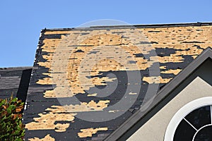 Wind damaged house roof with missing asphalt shingles after hurricane Ian in Florida. Repair of home rooftop concept