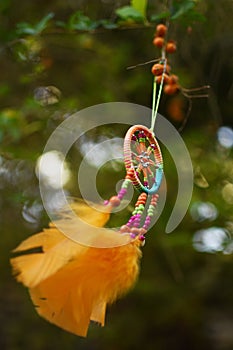 The wind is developed by the orange dreamcatcher suspended on a tree
