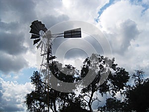 WIND DRIVEN WINDPUMP AGAINST DARK CLOUDS