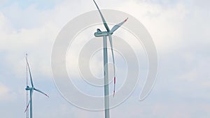 Wind energy turbines are one of the cleanest, renewable electric energy source, under blue sky, with zoom out