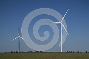 Wind energy turbines on sunset sky background, Energy generator nature friendly. Spring field.