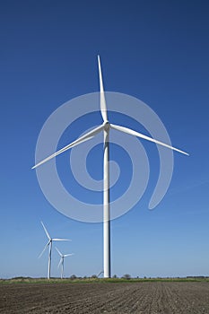 Wind energy turbines on sunset sky background, Energy generator nature friendly. Spring field.