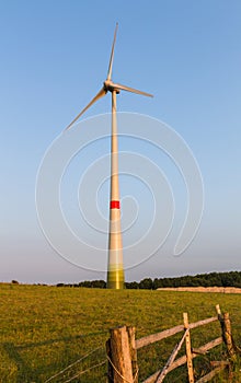 Wind engine on a meadow behind