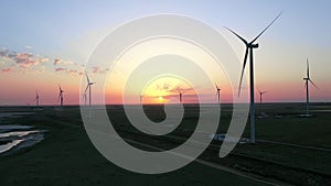 A wind farm against the backdrop of a beautiful evening golden sunset. Renewable energy production for a green