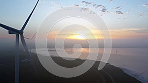 Wind farm against the backdrop of a beautiful evening golden sunset Renewable energy production for a green ecological