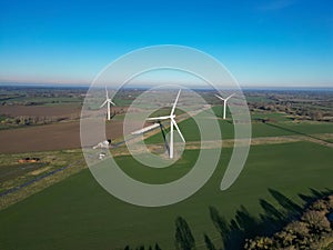 Wind farm featuring several wind turbines in a green field. The UK.