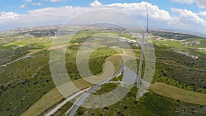 Wind farm near factory, lush green landscape untouched by technical progress