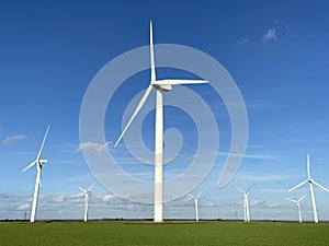 Wind turbines that produce electricity energy. Windmill Wind power technology productions Wind turbines in field photo