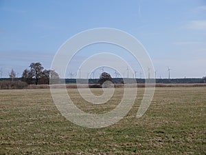 Wind farm with turbines viewed over a farm field