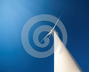 Wind generator against blue sky. Minimalistic shot, dramatic perspective