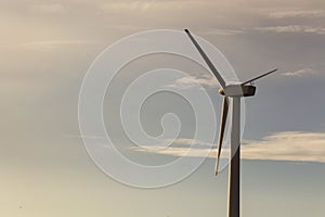 Wind generator on blue sky background. electricity production. place for text, at sunset