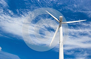 Wind generator of electricity from three blades against the background of clouds and blue sky
