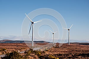 Wind generator in a field. Blue cloudy sky in the background. Orange warm color grass. Modern technology in natural environment.