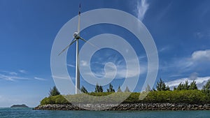 The wind generator is located on an island near the ocean.