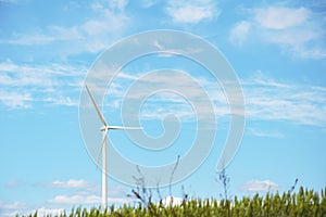 Wind generator, wind power plant, wind turbine against a blue sky with clouds. Device for converting wind energy into electricity