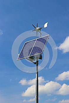 Wind generator and solar panel on a blue sky. Photovoltaic cells. Method of obtaining alternative energy. Ecologically clean elect