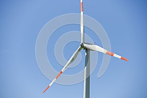 Wind generator turbine isolated on the blue sky, close-up