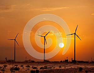 Wind generator turbines sihouettes on sunset photo