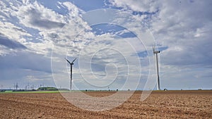 Wind generators and tractor plows the field