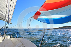 The wind has filled colorful spinnaker sail