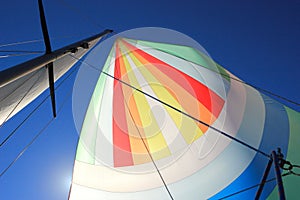 The wind has filled colorful spinnaker sail