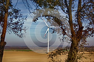 Wind machines among fields against bright sky