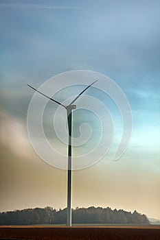 Wind machines among fields against bright sky