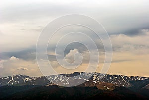 Wind matured clouds and snowy mountain peaks moody scene