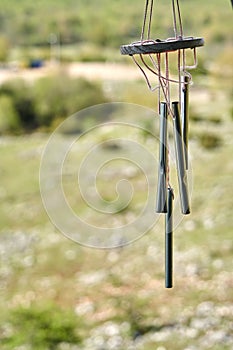 Wind organ made of narrow cylinders of aluminum, cropped in front of out of focus background