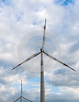 Wind power complex of Rosatom.  Blades on towers of wind turbines at sunset against cloudy sky. Close-up. Adyghe wind farm