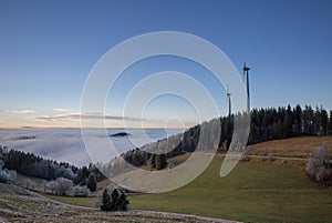 Wind power mills above fog in black forest